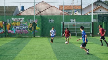 Depok, Endonezya - 11 Ekim 2021: Futbol oynayan genç futbolcular grubu. Futbol takımları arasındaki futbol maçı