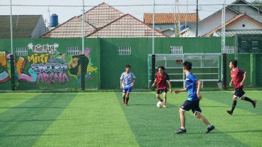 Depok, Endonezya - 11 Ekim 2021: Futbol oynayan genç futbolcular grubu. Futbol takımları arasındaki futbol maçı