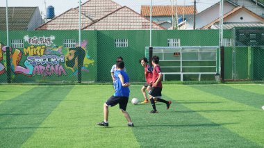 Depok, Endonezya - 11 Ekim 2021: Futbol oynayan genç futbolcular grubu. Futbol takımları arasındaki futbol maçı
