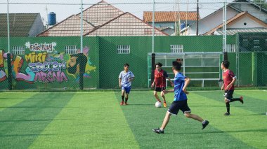 Depok, Endonezya - 11 Ekim 2021: Futbol oynayan genç futbolcular grubu. Futbol takımları arasındaki futbol maçı