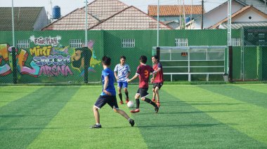 Depok, Endonezya - 11 Ekim 2021: Futbol oynayan genç futbolcular grubu. Futbol takımları arasındaki futbol maçı