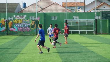 Depok, Endonezya - 11 Ekim 2021: Futbol oynayan genç futbolcular grubu. Futbol takımları arasındaki futbol maçı