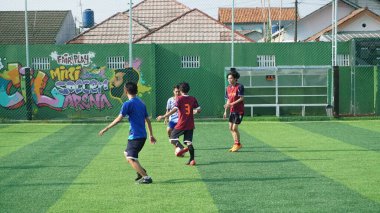 Depok, Endonezya - 11 Ekim 2021: Futbol oynayan genç futbolcular grubu. Futbol takımları arasındaki futbol maçı