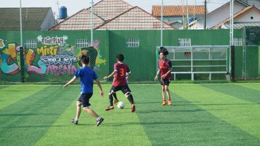 Depok, Endonezya - 11 Ekim 2021: Futbol oynayan genç futbolcular grubu. Futbol takımları arasındaki futbol maçı