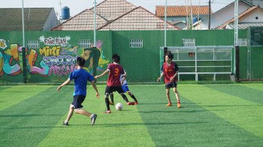 Depok, Endonezya - 11 Ekim 2021: Futbol oynayan genç futbolcular grubu. Futbol takımları arasındaki futbol maçı