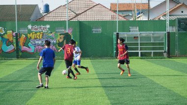Depok, Endonezya - 11 Ekim 2021: Futbol oynayan genç futbolcular grubu. Futbol takımları arasındaki futbol maçı
