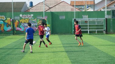 Depok, Endonezya - 11 Ekim 2021: Futbol oynayan genç futbolcular grubu. Futbol takımları arasındaki futbol maçı