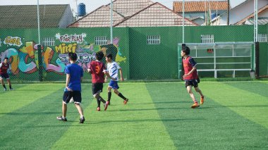 Depok, Endonezya - 11 Ekim 2021: Futbol oynayan genç futbolcular grubu. Futbol takımları arasındaki futbol maçı