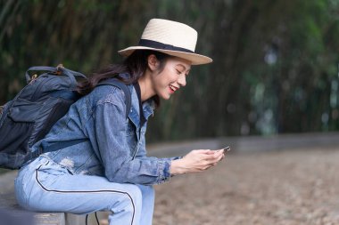 Genç Asyalı kadın tatilde ormanı keşfediyor.