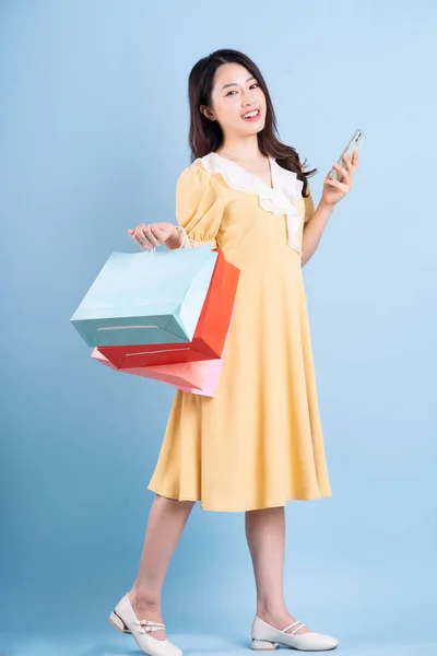 Bella Giovane Donna Asiatica Possesso Shopping Bag Sfondo Blu — Foto Stock