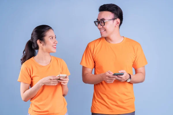 Unga Asiatiska Par Bär Orange Shirt Blå Bakgrund — Stockfoto