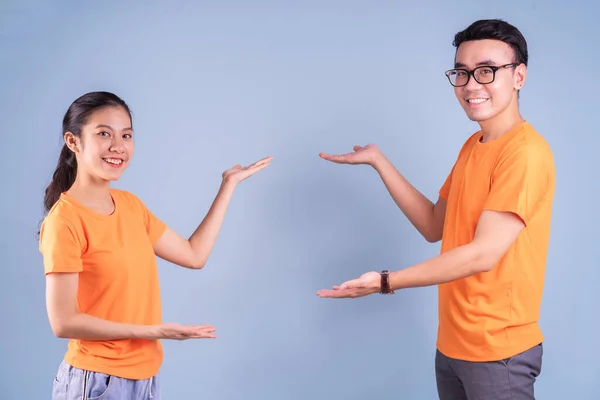 Młoda Azjatycka Para Pomarańczowej Koszulce Niebieskim Tle — Zdjęcie stockowe