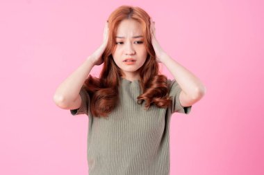 Pembe arka planda poz veren genç Asyalı kadın