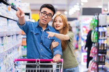 Asyalı yeni evliler süpermarketten alışveriş yapıyorlar.