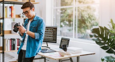 Genç Asyalı fotoğrafçı fotoğrafını kontrol ediyor.