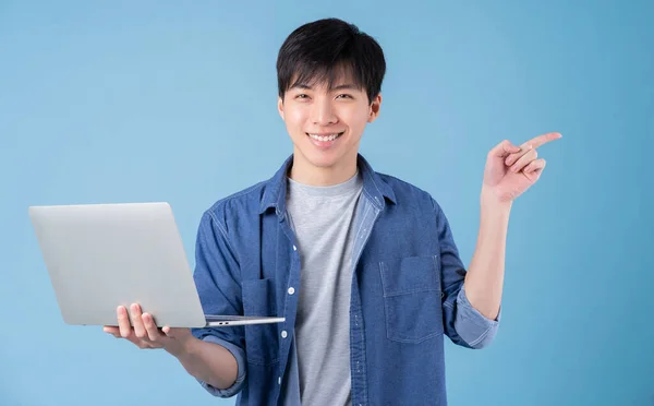 Молодой Азиат Использует Ноутбук Синем Фоне — стоковое фото