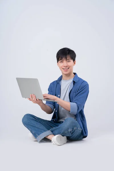 Молодой Азиат Сидит Использует Ноутбук Белом Фоне — стоковое фото