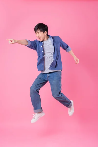 Молодой Азиат Прыгает Синем Фоне — стоковое фото