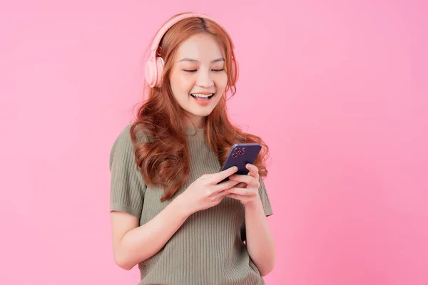 Mladá Asijská Žena Pomocí Smartphone Poslech Hudby Růžovém Pozadí — Stock fotografie