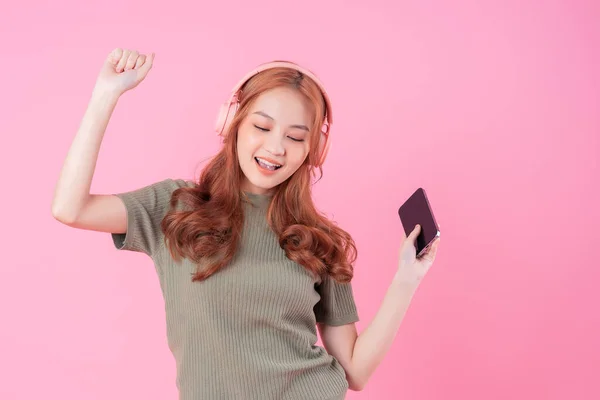 Молода Азіатка Користується Смартфоном Слухає Музику Рожевому Фоні — стокове фото