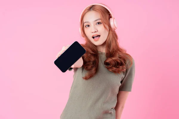 Junge Asiatin Nutzt Smartphone Und Hört Musik Auf Rosa Hintergrund — Stockfoto