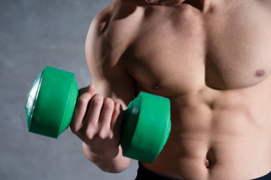 Gri arka planda poz veren kaslı Asyalı adam