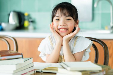 Asyalı çocuk evde okuyor.