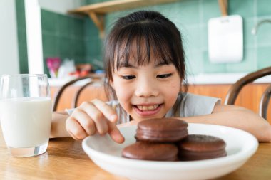 Asyalı çocuk evde kahvaltı yapıyor.