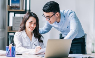 Ofiste çalışan iki Asyalı iş adamı