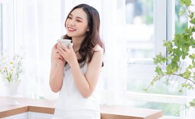 Güzel bir Asyalı kadının sabah evde çay içişi.