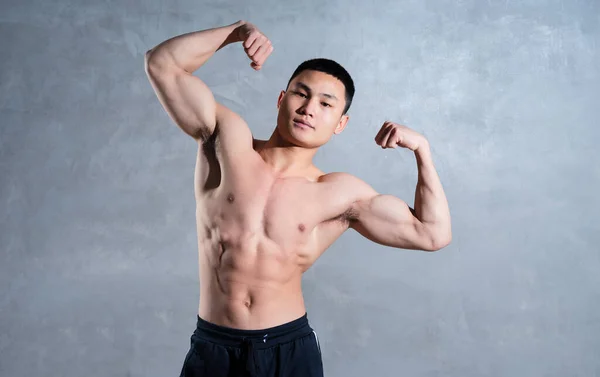 Muskulöse Asiatische Mann Posiert Auf Grauem Hintergrund — Stockfoto