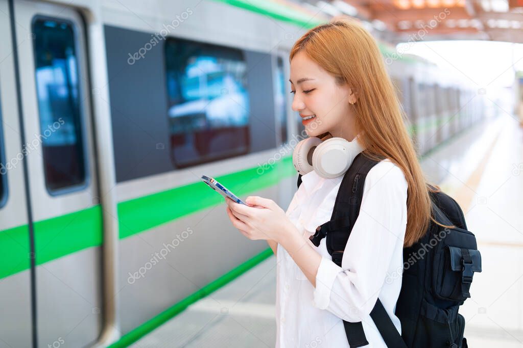 Young Asian girl waiting for the train at the station