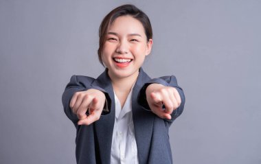 Gri arka planda güzel bir Asyalı iş kadınının portresi.