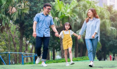 Parkta birlikte oynayan Asyalı genç bir ailenin görüntüsü