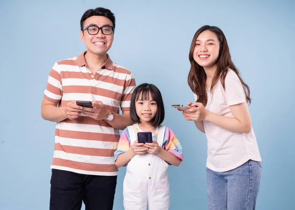 Immagine Della Giovane Famiglia Asiatica Con Smartphone Sfondo Blu — Foto Stock