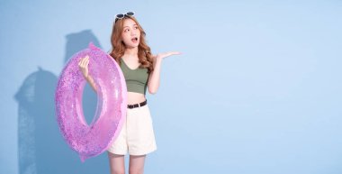 Mavi arka planda yüzen Asyalı genç bir kız resmi, yaz tatili konsepti.