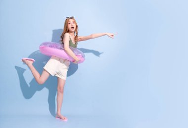 Mavi arka planda yüzen Asyalı genç bir kız resmi, yaz tatili konsepti.