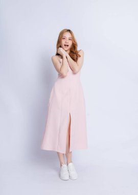 Beyaz arka planda elbise giyen genç Asyalı kadının tam boy görüntüsü