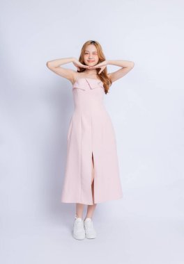 Beyaz arka planda elbise giyen genç Asyalı kadının tam boy görüntüsü