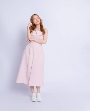 Beyaz arka planda elbise giyen genç Asyalı kadının tam boy görüntüsü