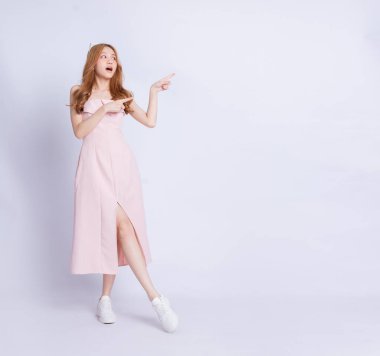 Beyaz arka planda elbise giyen genç Asyalı kadının tam boy görüntüsü