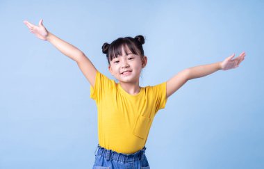 Mavi arkaplanda poz veren Asyalı çocuk resmi