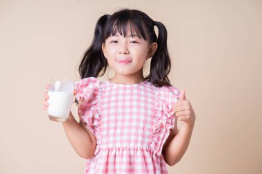 Arka planda süt içen Asyalı çocuk görüntüsü