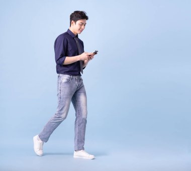 Mavi arka planda genç Asyalı iş adamının tam boy görüntüsü