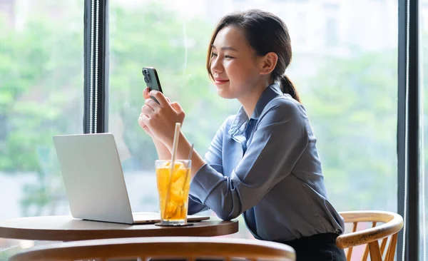 Kafede çalışan Asyalı genç iş kadınının resmi