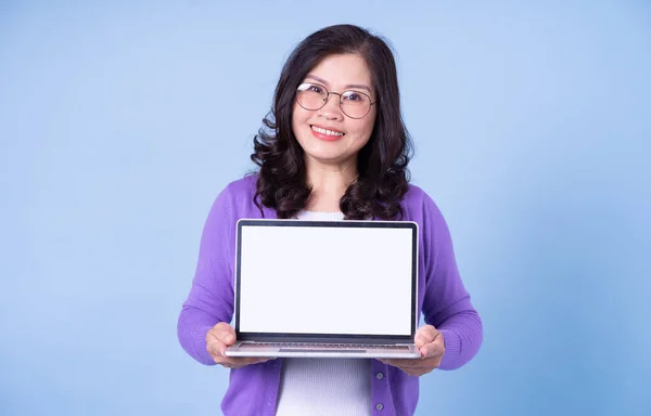 Portrait Middle Aged Asian Woman Using Laptop Blue Background — Fotografia de Stock
