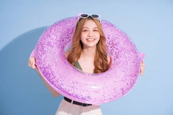 Mavi arka planda yüzen Asyalı genç bir kız resmi, yaz tatili konsepti.