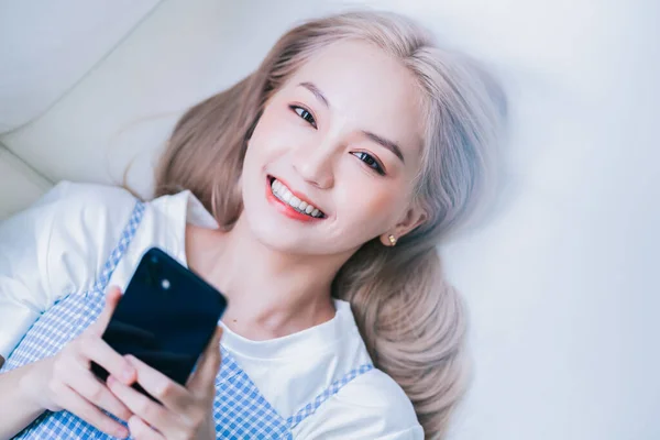 Young Asian Girl Using Smartphone Home — Stockfoto
