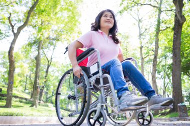 Tekerlekli sandalyede oturan orta yaşlı Asyalı kadın.