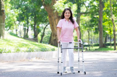 Orta yaşlı Asyalı bir kadının parkta yürüme çalışması.